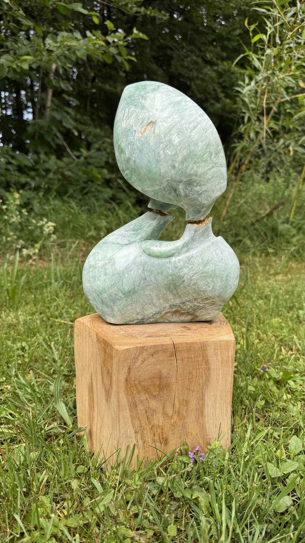 Energy Flow auf einem Holzsockel im Garten
