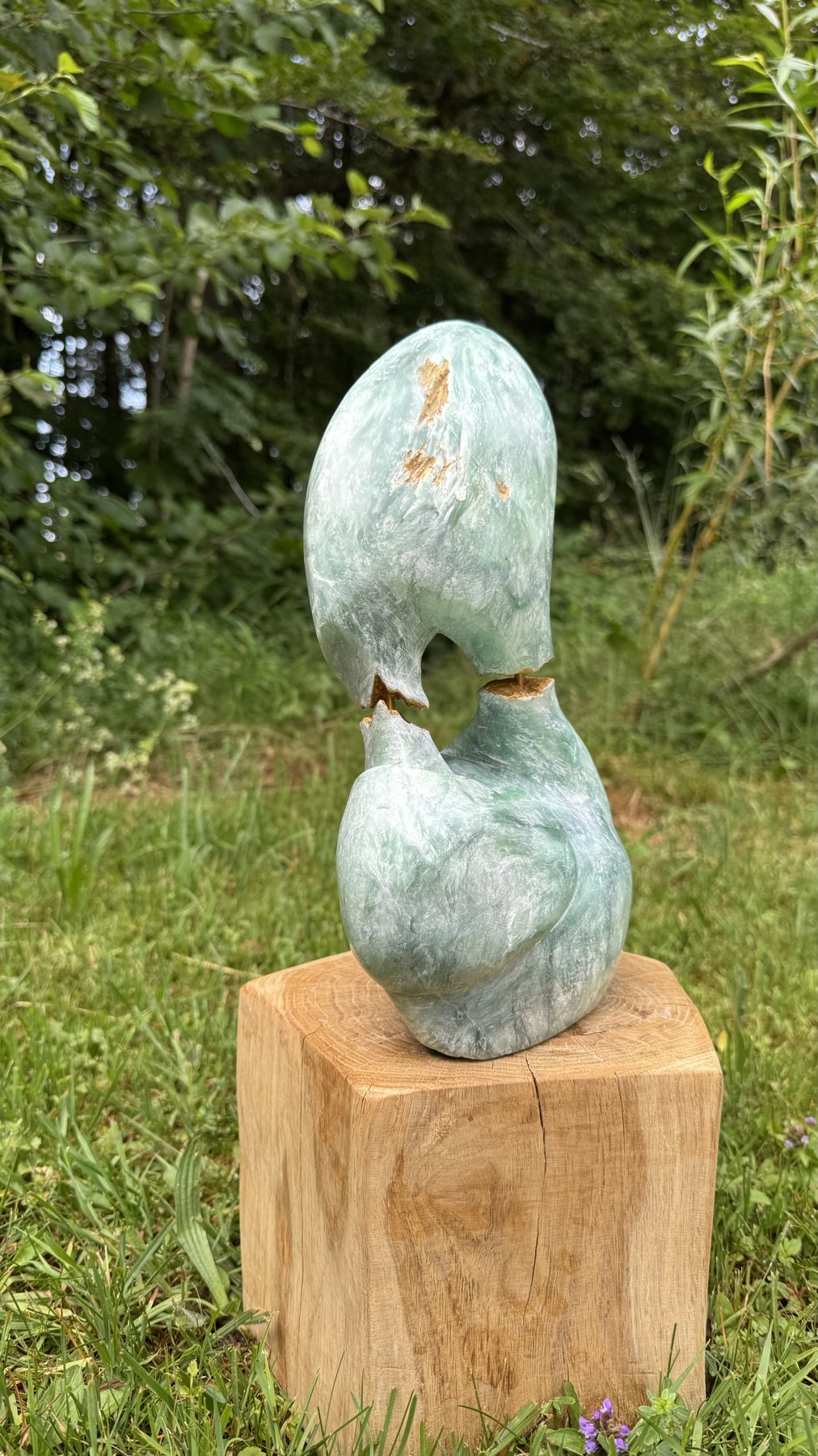 Energy Flow auf einem Holzsockel im Garten, Frontansicht